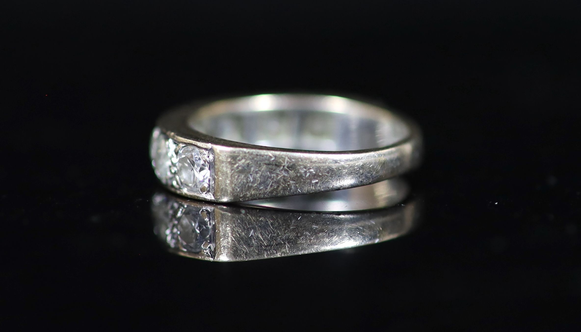 A modern white gold and channel set seven stone diamond half hoop ring